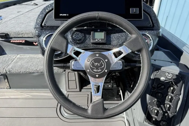 Slide: The Image of Steering wheel of 2026 Phoenix 920 Elite X boat with dashboard controls. - 20