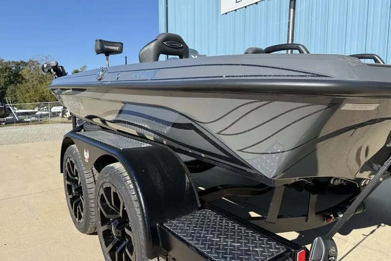 Slide: The Image of 2026 Phoenix 920 Elite X boat on trailer, sleek gray design, parked outdoors. - 9
