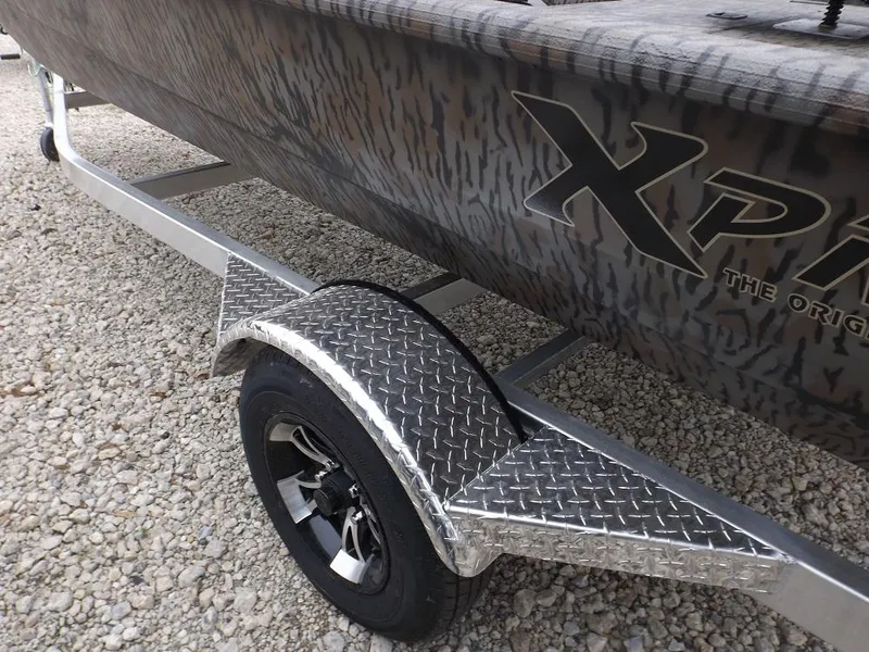 Slide: The Image of 2019 Xpress XP180 boat on a trailer with diamond plate fender, parked on gravel. - 4