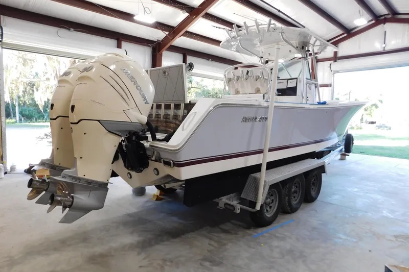 Slide: The Image of 2003 Regulator 32 Center Console boat with twin Mercury engines in a garage. - 13
