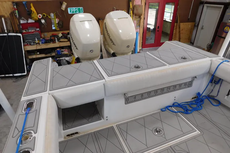 Slide: The Image of 2003 Regulator 32 Center Console boat with dual Mercury engines in a workshop setting. - 15