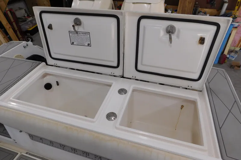 Slide: The Image of 2003 Regulator 32 Center Console storage compartments with open lids in a garage setting. - 21