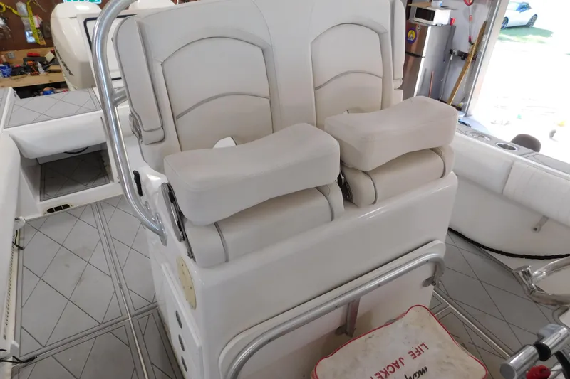 Slide: The Image of 2003 Regulator 32 Center Console boat interior with cushioned seating and safety equipment. - 24