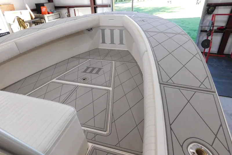 Slide: The Image of 2003 Regulator 32 Center Console boat interior with cushioned seating and diamond-patterned flooring. - 26