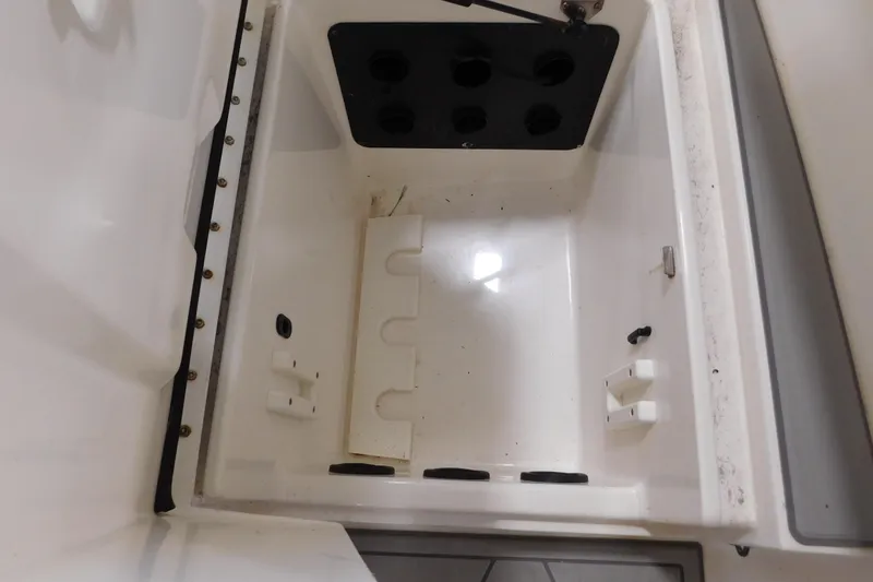 Slide: The Image of Storage compartment of a 2003 Regulator 32 Center Console boat, featuring rod holders. - 27