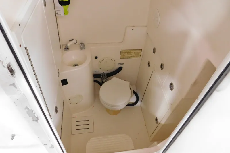 Slide: The Image of 2003 Regulator 32 Center Console boat bathroom with toilet and sink. - 28