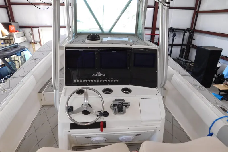 Slide: The Image of 2003 Regulator 32 Center Console boat interior with steering wheel and control panel. - 37