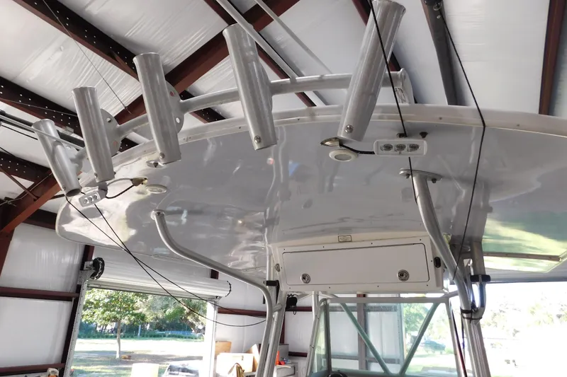 Slide: The Image of 2003 Regulator 32 Center Console boat with rod holders in a storage facility. - 38