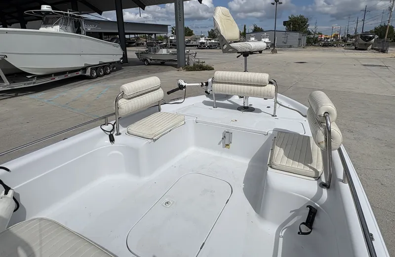 Slide: The Image of 2000 Fishmaster 23 boat with seating, parked outdoors under a cloudy sky. - 7