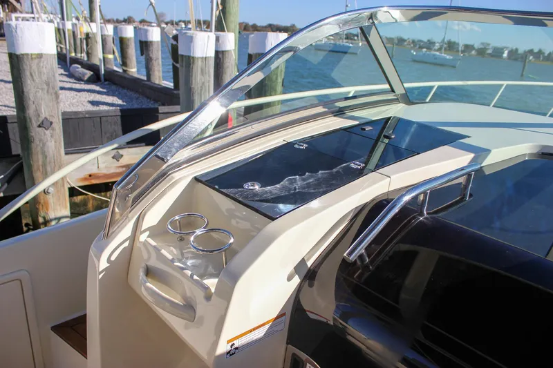 Slide: The Image of 2017 Chris-Craft Launch 38 interior with teak accents and cup holders by the water. - 56
