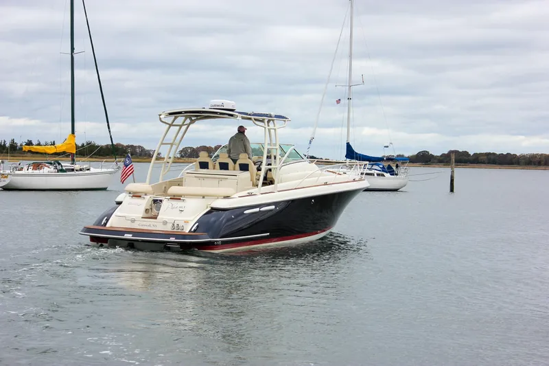 Slide: The Image of 2017 Chris-Craft Launch 38 boat cruising in a calm harbor with sailboats nearby. - 97