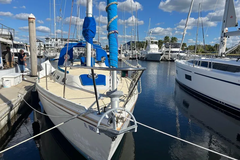 Slide: The Image of 1988 Catalina 34 mkI sailboat docked in a marina under a blue sky. - 1