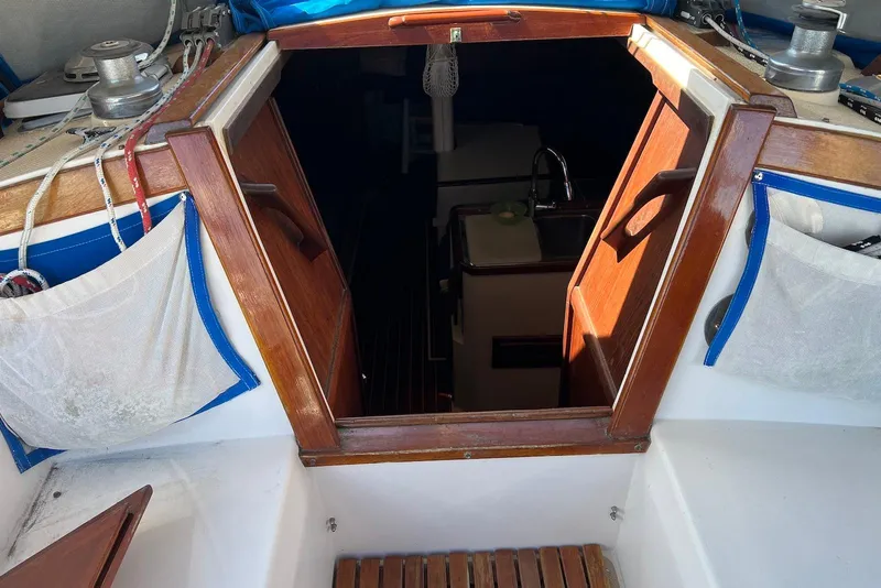 Slide: The Image of 1988 Catalina 34 mkI sailboat cabin entrance with wooden trim and visible interior. - 12