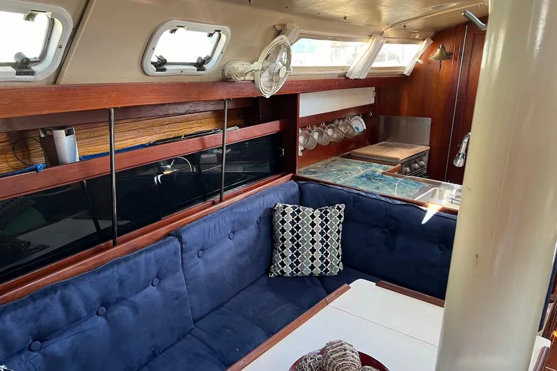 Slide: The Image of Interior of a 1988 Catalina 34 mkI sailboat with blue seating and wooden accents. - 17