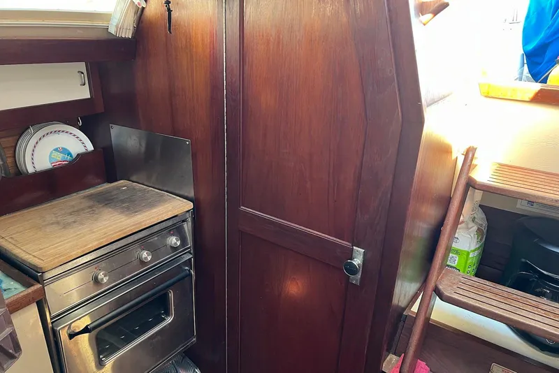 Slide: The Image of Interior of 1988 Catalina 34 mkI sailboat with wooden cabinetry and compact kitchen area. - 18