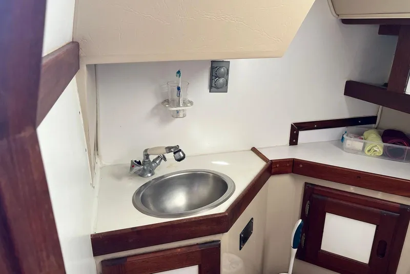 Slide: The Image of 1988 Catalina 34 mkI yacht interior with compact sink and storage area. - 25