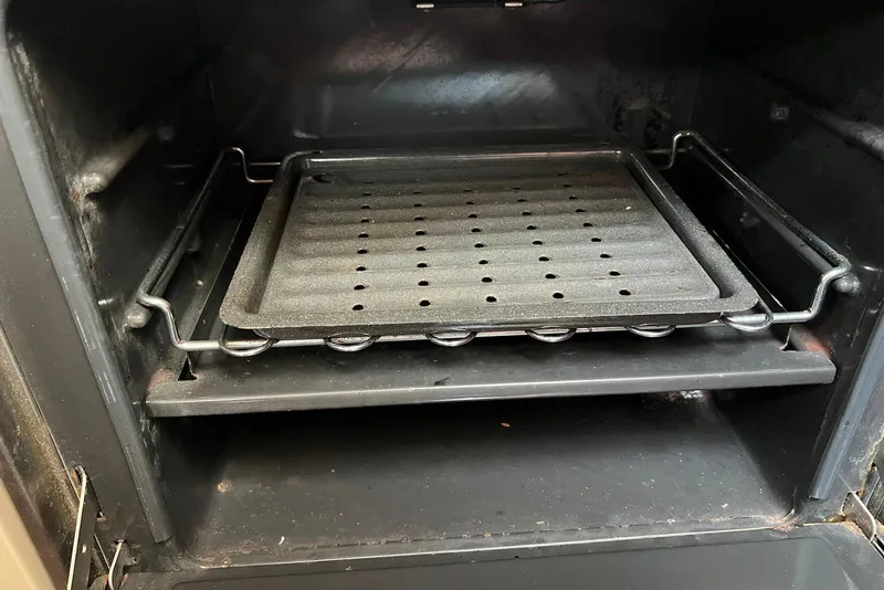 Slide: The Image of Empty oven with a perforated baking tray inside, viewed from the front. - 35