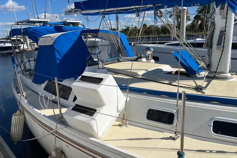 Slide: The Image of 1988 Catalina 34 mkI sailboat with blue covers docked at marina. - 8