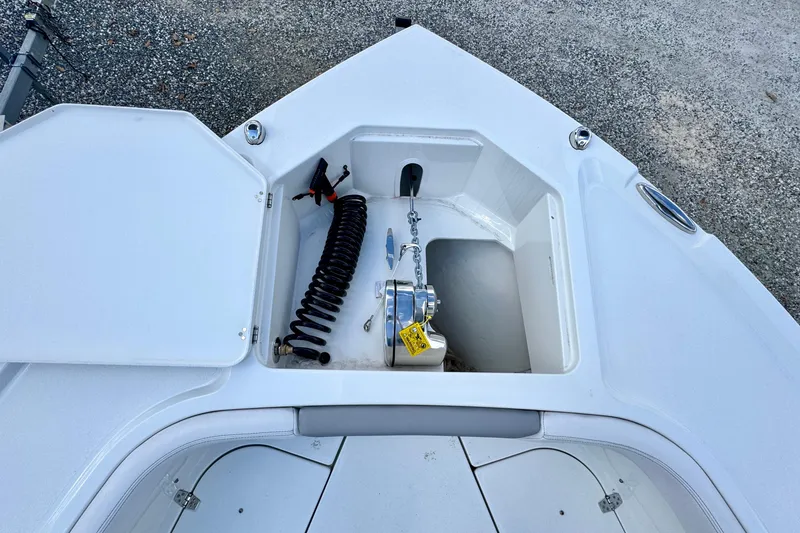 Slide: The Image of 2025 Parker 2600 Center Console boat anchor compartment with coiled hose and chain. - 15