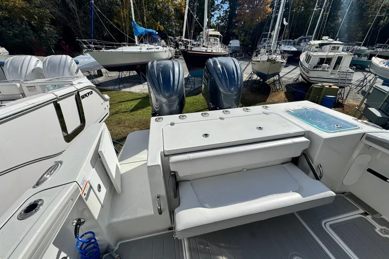Slide: The Image of 2025 Parker 2600 Center Console boat with dual engines, docked among sailboats. - 38