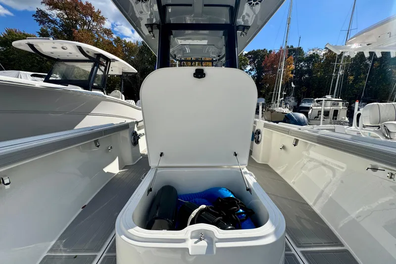 Slide: The Image of 2025 Parker 2600 Center Console boat with open storage compartment, docked outdoors. - 42