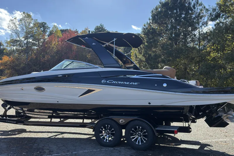 Slide: The Image of 2026 Crownline 298 SS boat on trailer, surrounded by autumn trees. - 16