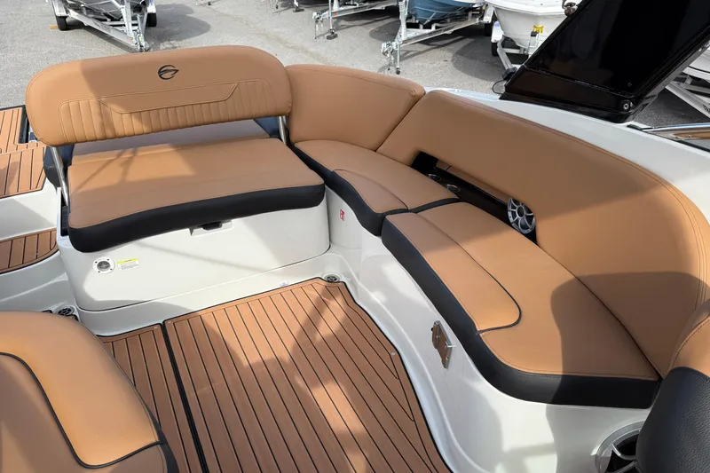 Slide: The Image of 2026 Crownline 298 SS boat on trailer, parked outdoors with trees in background. - 2