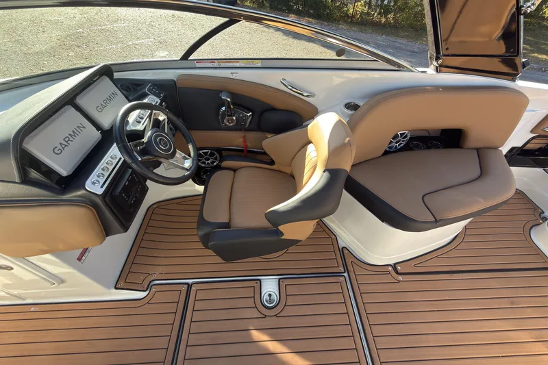 Slide: The Image of 2026 Crownline 298 SS boat interior with Garmin displays and tan seating. - 9