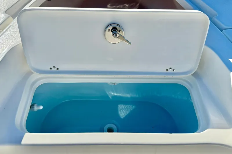 Slide: The Image of Open storage compartment on 2026 Key West 230 Bay Reef boat, featuring a blue interior. - 19