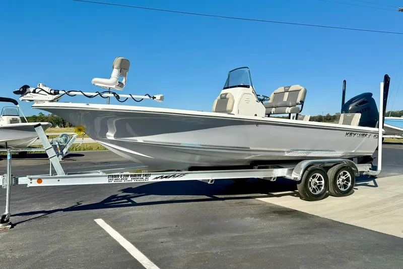 Slide: The Image of 2026 Key West 230 Bay Reef boat on trailer, parked outdoors under clear blue sky. - 4