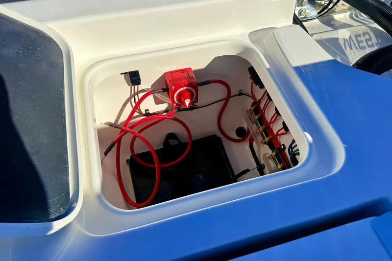 Slide: The Image of Electrical compartment of 2026 Key West 230 Bay Reef boat with red wiring and battery switch. - 43