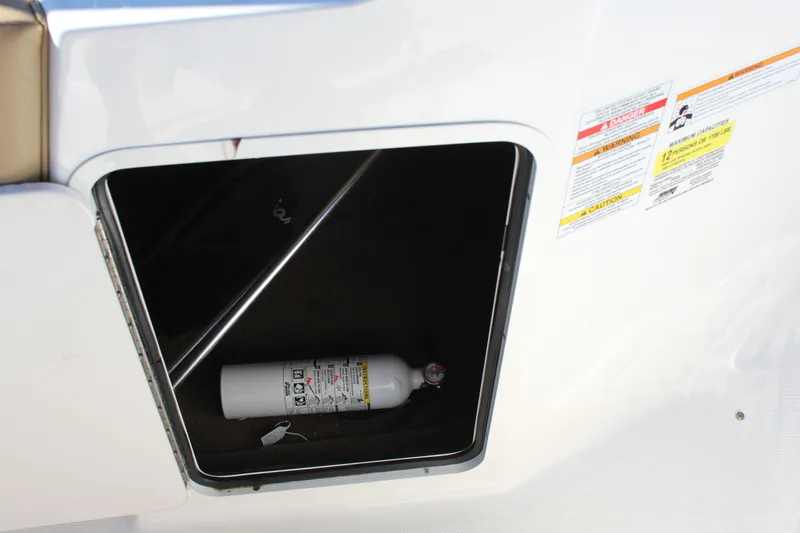Slide: The Image of Storage compartment on 2023 Sea Ray SPX 210 boat with fire extinguisher inside. - 16