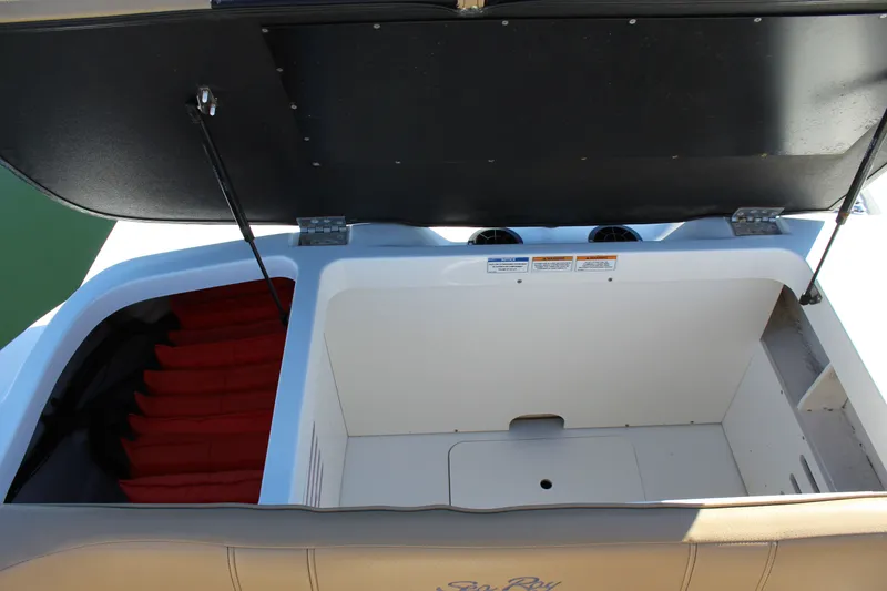 Slide: The Image of 2023 Sea Ray SPX 210 boat storage compartment with open lid, showcasing spacious interior. - 27