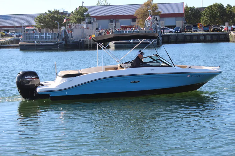 Slide: The Image of 2023 Sea Ray SPX 210 boat cruising on calm water near a marina. - 4