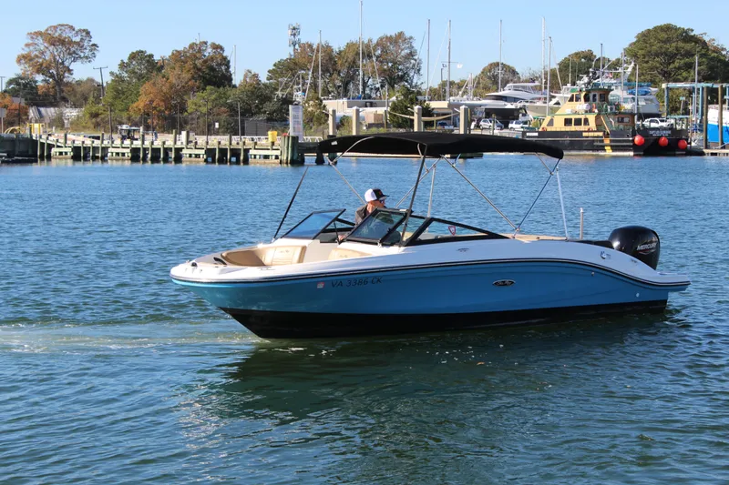 Slide: The Image of 2023 Sea Ray SPX 210 boat cruising on a sunny day near a marina. - 8