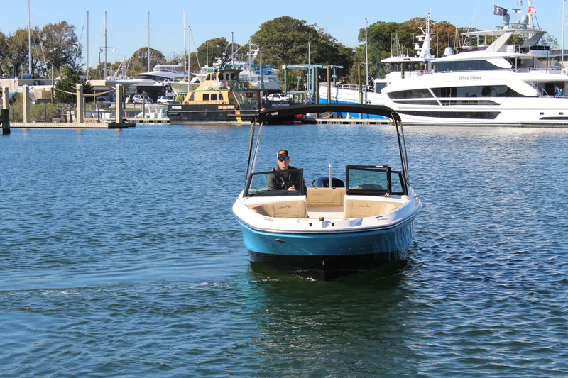 Slide: The Image of 2023 Sea Ray SPX 210 boat cruising in a marina with yachts in the background. - 9