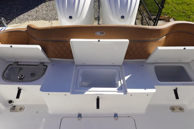 Slide: The Image of 2026 Sea Hunt Ultra 285 Coffin Box boat interior with brown cushioned seating. - 9