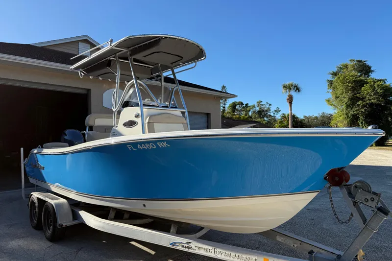 Slide: The Image of 2017 NauticStar 2302 Legacy boat on trailer, blue hull, parked outdoors. - 2