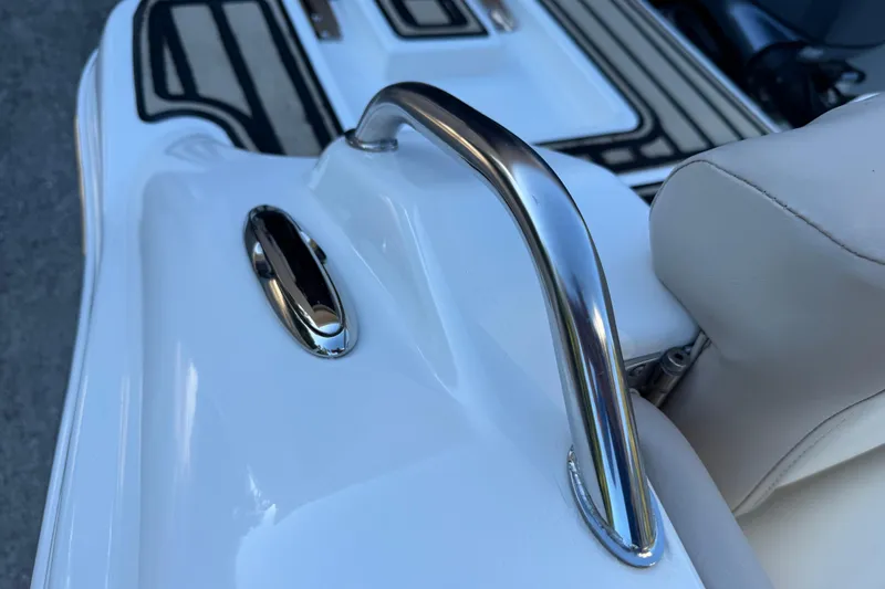 Slide: The Image of 2017 NauticStar 2302 Legacy boat interior with chrome handle and white seating. - 20