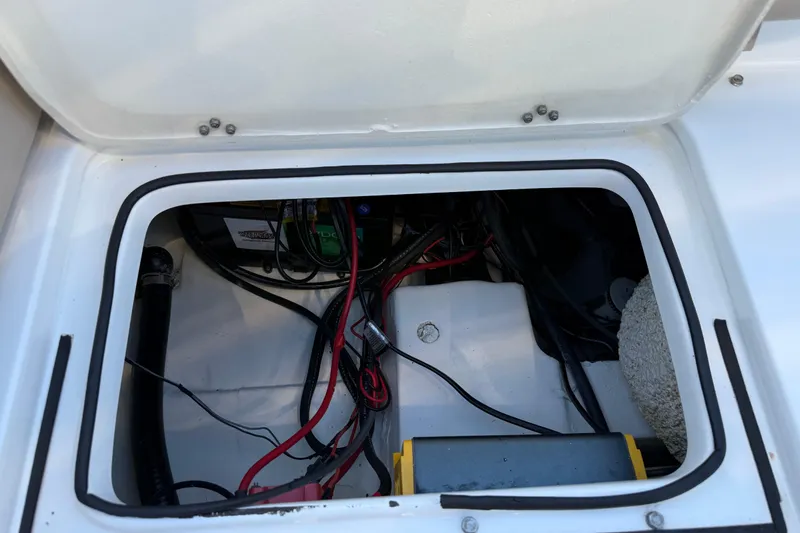 Slide: The Image of Open hatch of 2017 NauticStar 2302 Legacy boat showing internal wiring and components. - 23