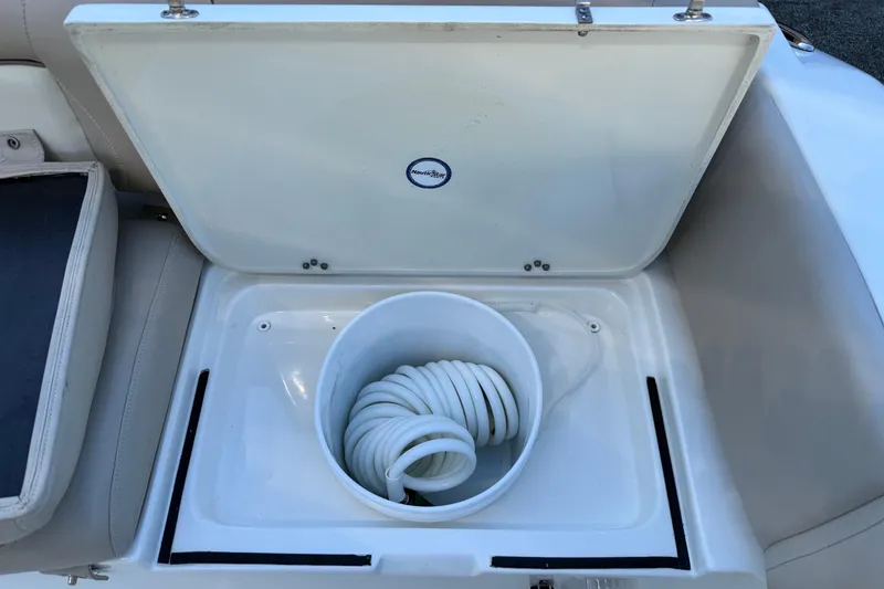 Slide: The Image of Storage compartment with coiled hose on a 2017 NauticStar 2302 Legacy boat. - 26