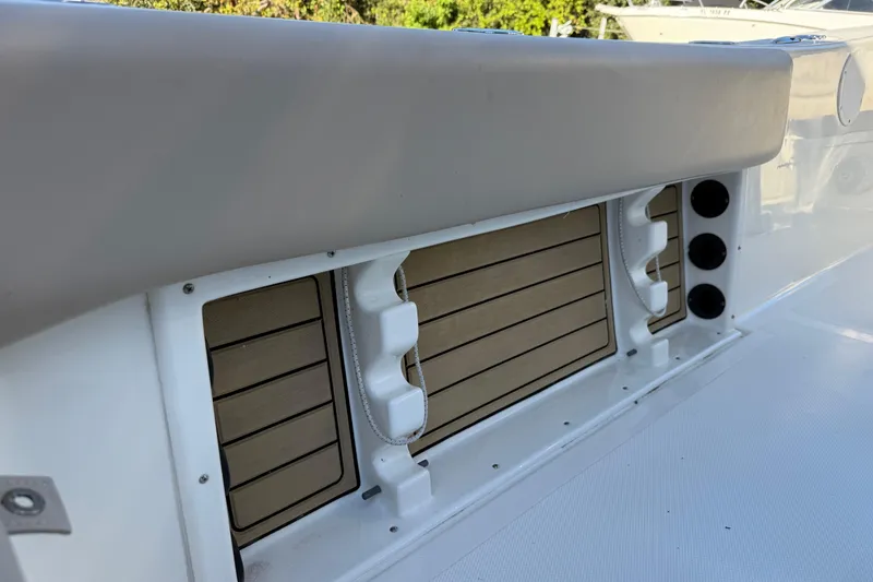 Slide: The Image of 2017 NauticStar 2302 Legacy boat interior detail with storage compartments and rod holders. - 29