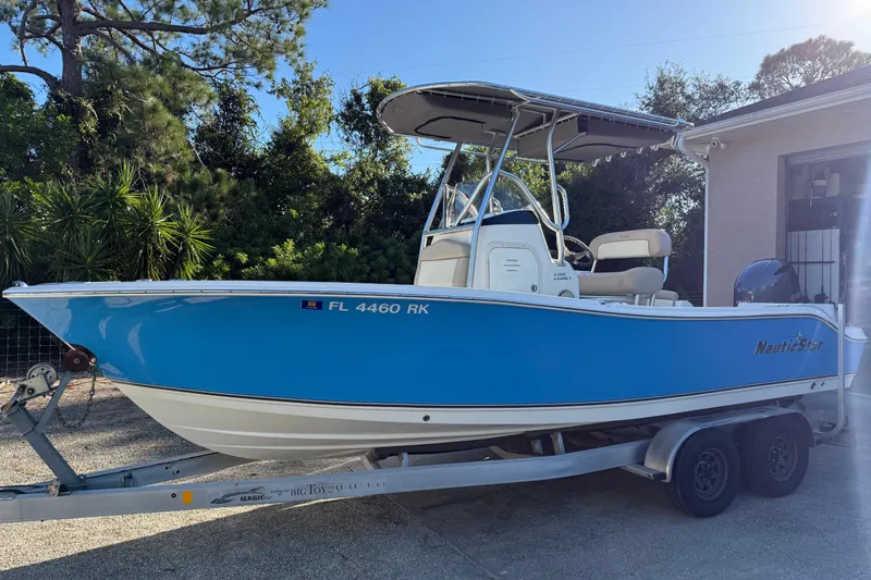 Slide: The Image of 2017 NauticStar 2302 Legacy boat on trailer, blue hull, parked outdoors. - 3