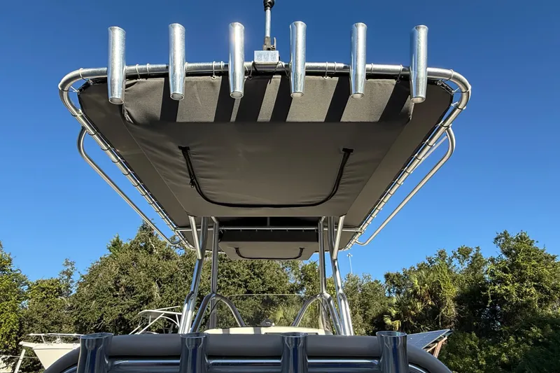 Slide: The Image of 2017 NauticStar 2302 Legacy boat with T-top and rod holders against clear blue sky. - 35