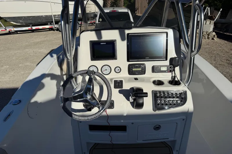 Slide: The Image of 2017 NauticStar 2302 Legacy boat console with steering wheel and navigation equipment. - 37