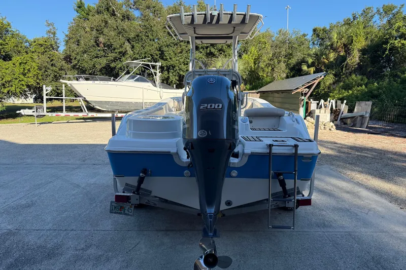 Slide: The Image of 2017 NauticStar 2302 Legacy boat with Yamaha 200 engine, parked outdoors. - 5