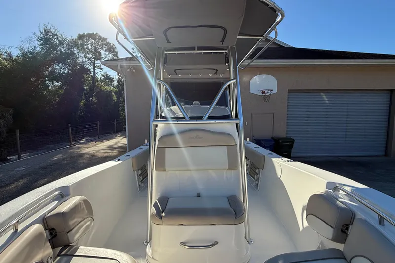 Slide: The Image of 2017 NauticStar 2302 Legacy boat with seating, under sunny sky, near a garage. - 50