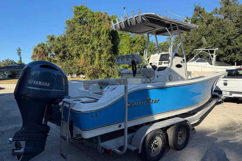 Slide: The Image of 2017 NauticStar 2302 Legacy boat with Yamaha engine on trailer, parked outdoors. - 6