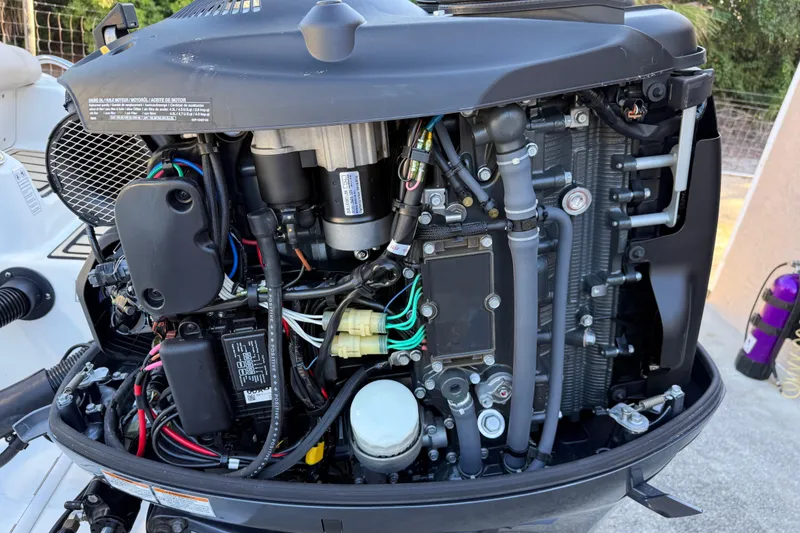 Slide: The Image of Close-up of a 2017 NauticStar 2302 Legacy boat engine, showcasing intricate components and wiring. - 9