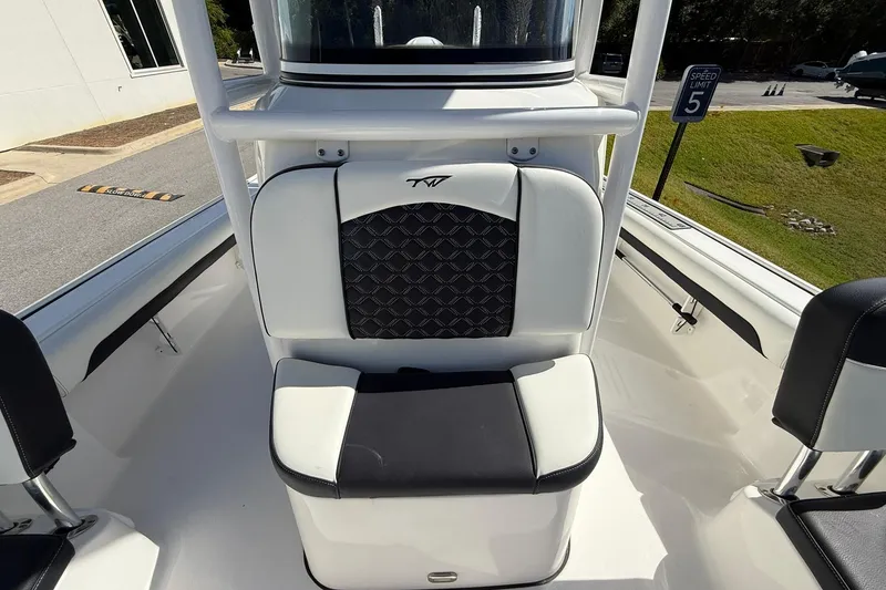 Slide: The Image of 2021 Tidewater 2500 Carolina Bay boat interior with cushioned seating and console. - 13